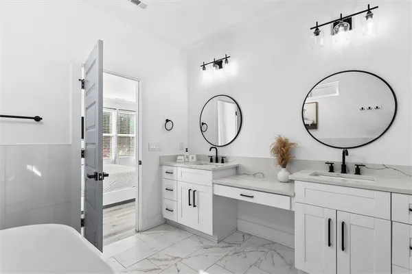 a bathroom with a double vanity sink mirror and toilet