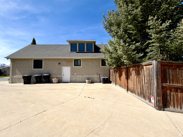 202 375 West Providence, UT 84332 - Photo 56 of 61 View of east side of home featuring a shingled roof, stucco siding, and a patio
