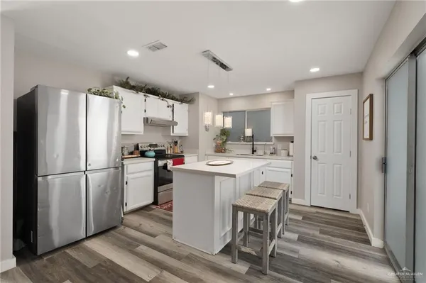 a kitchen with refrigerator and white cabinets
