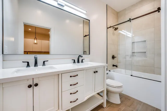 a bathroom with a granite countertop sink toilet and shower