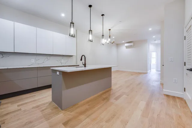 a kitchen with kitchen island a sink stainless steel appliances and cabinets