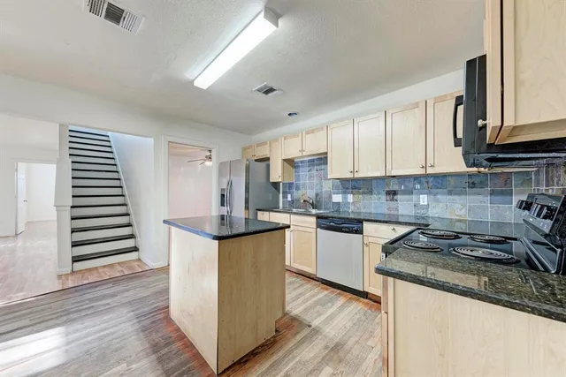 a kitchen with granite countertop a sink and a stove top oven