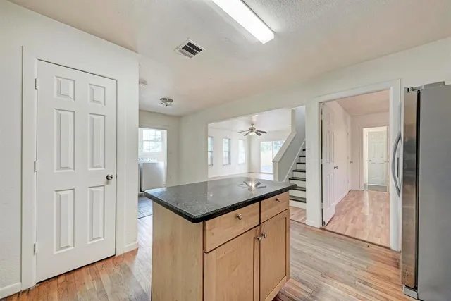 an empty room with wooden floor windows and hallway