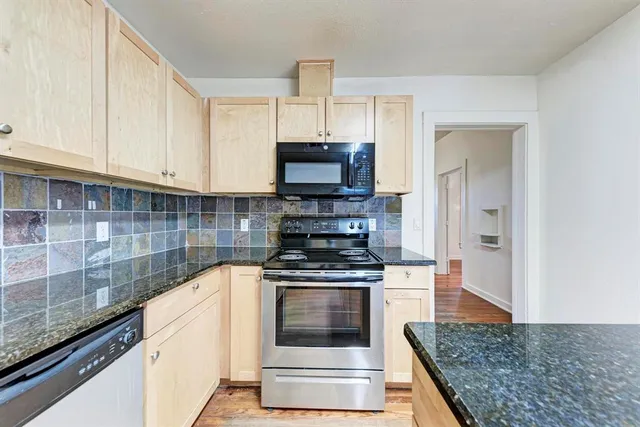 a kitchen with a stove and a white cabinets