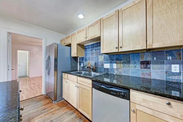 a kitchen with stainless steel appliances granite countertop a stove a sink and a refrigerator
