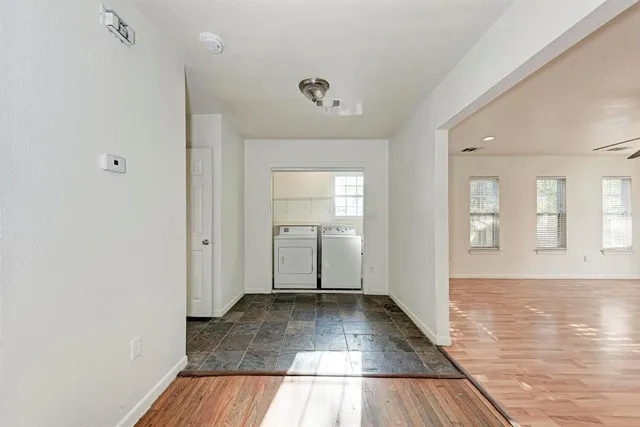 a view of a room with wooden floor and a ceiling fan