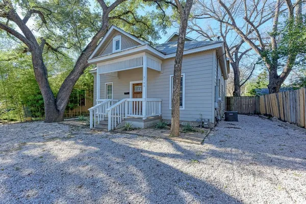 a view of a house with a yard and tree in the background