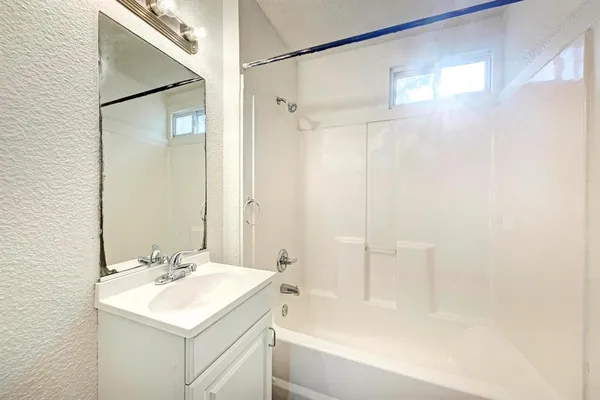 a bathroom with a sink mirror shower and a bathtub