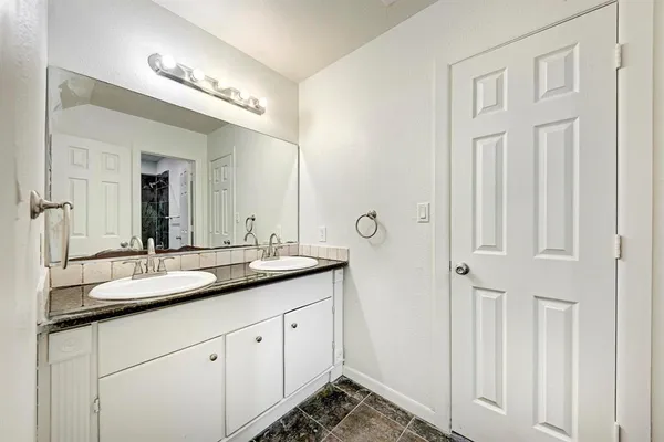 a bathroom with a granite countertop sink and a mirror