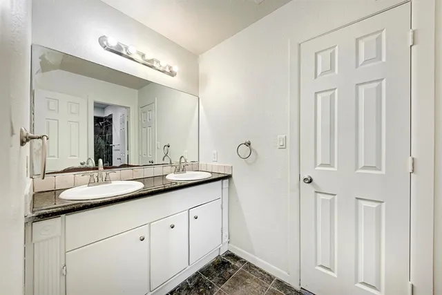 a bathroom with a granite countertop sink and a mirror