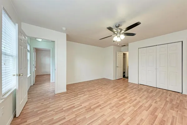 wooden floor in an empty room with a ceiling fan