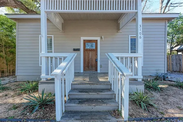 a view of front door with potted plants