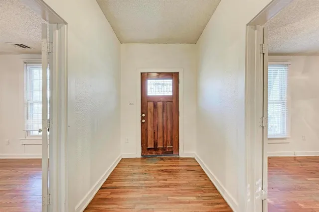 a view of a hallway with wooden floor