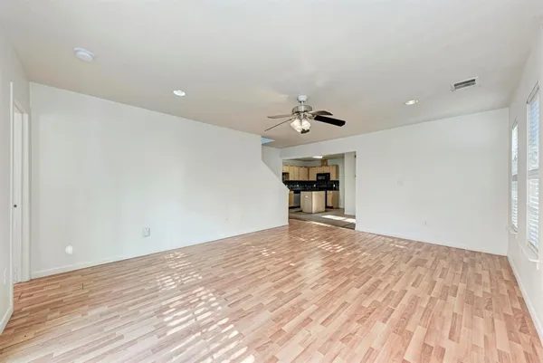 a view of empty room with wooden floor