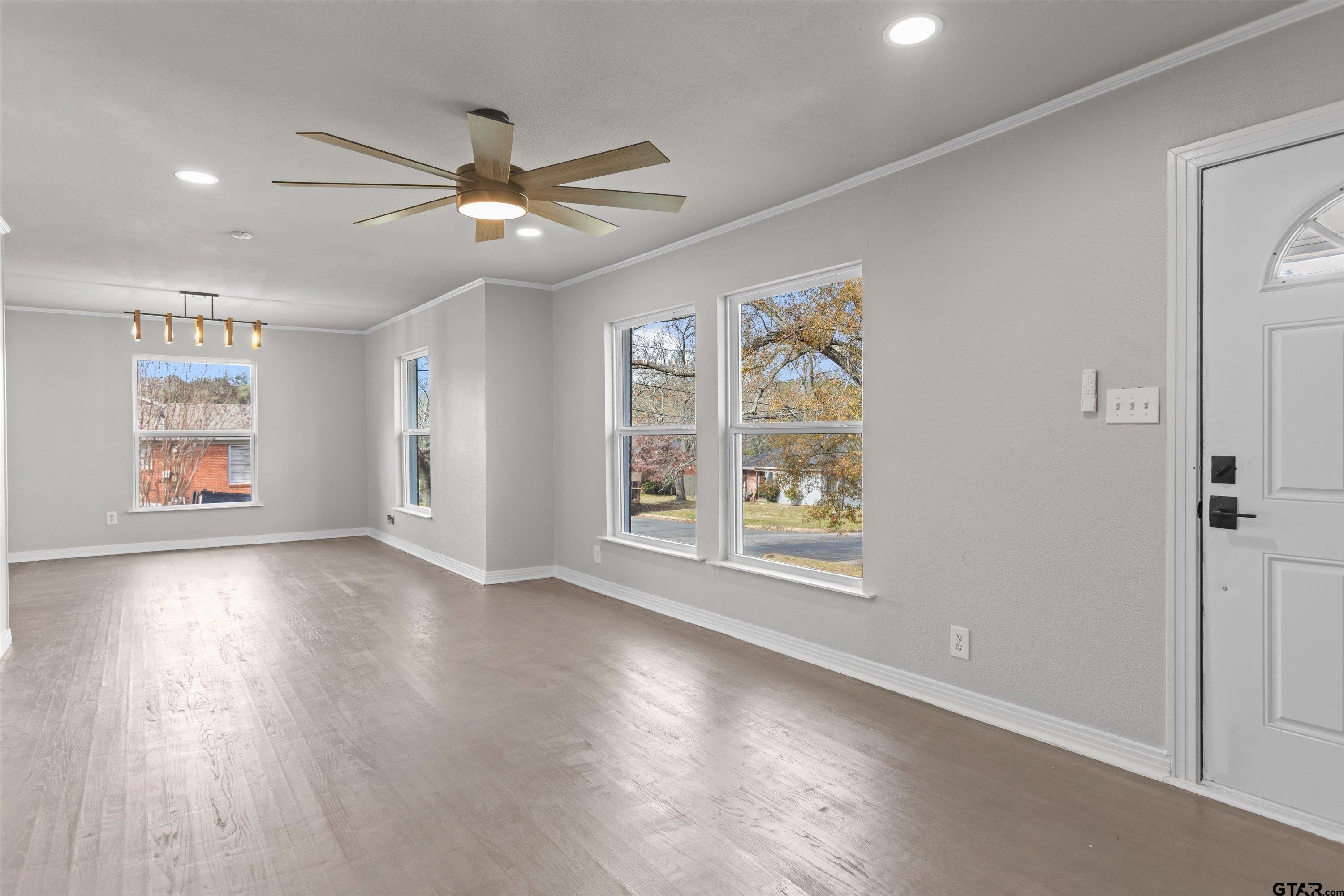 1330 Graham Drive Tyler, TX 75701 - Photo 4 of 22 a view of an empty room with a window and wooden floor