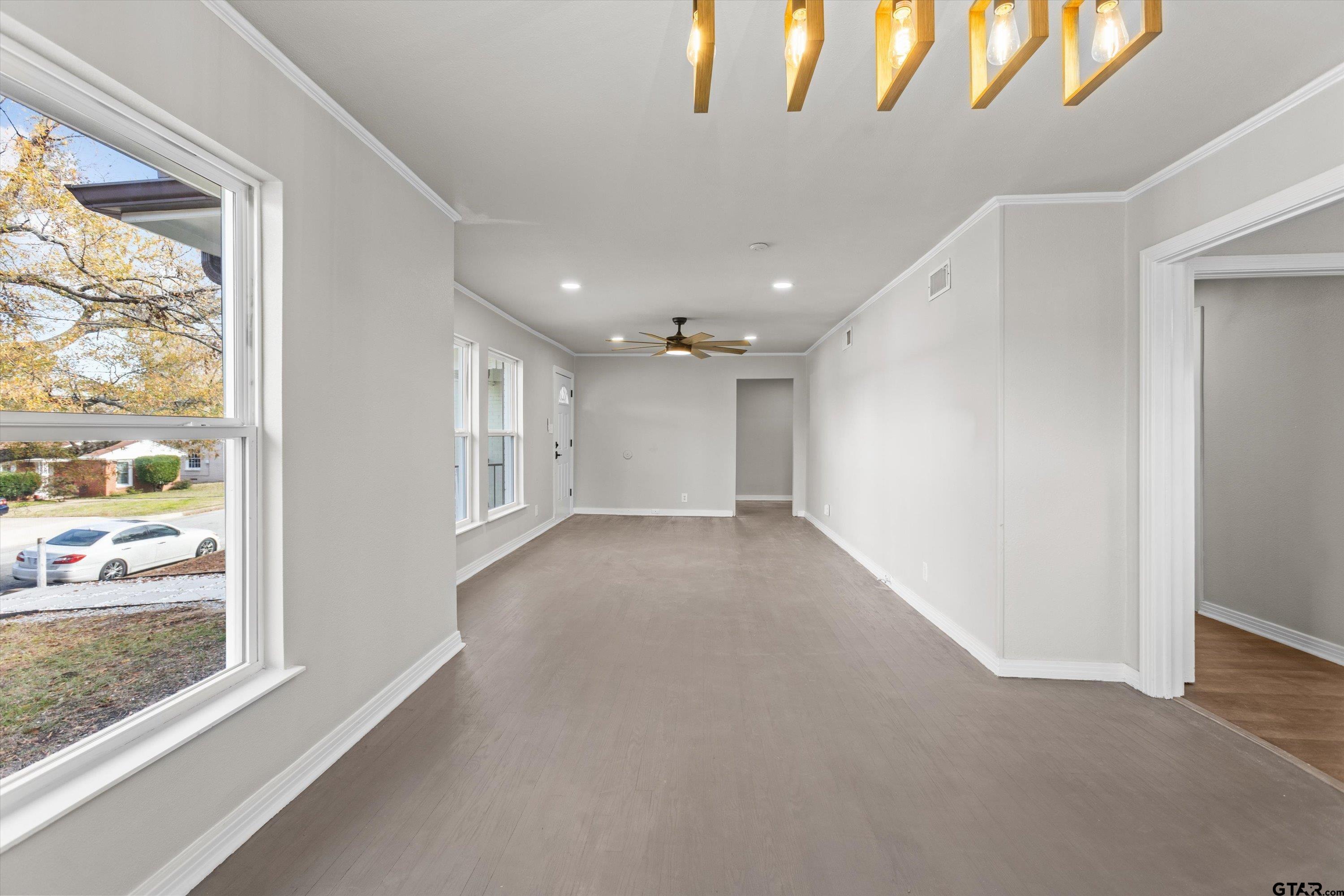 1330 Graham Drive Tyler, TX 75701 - Photo 5 of 22 a view of a hallway with wooden floor and windows