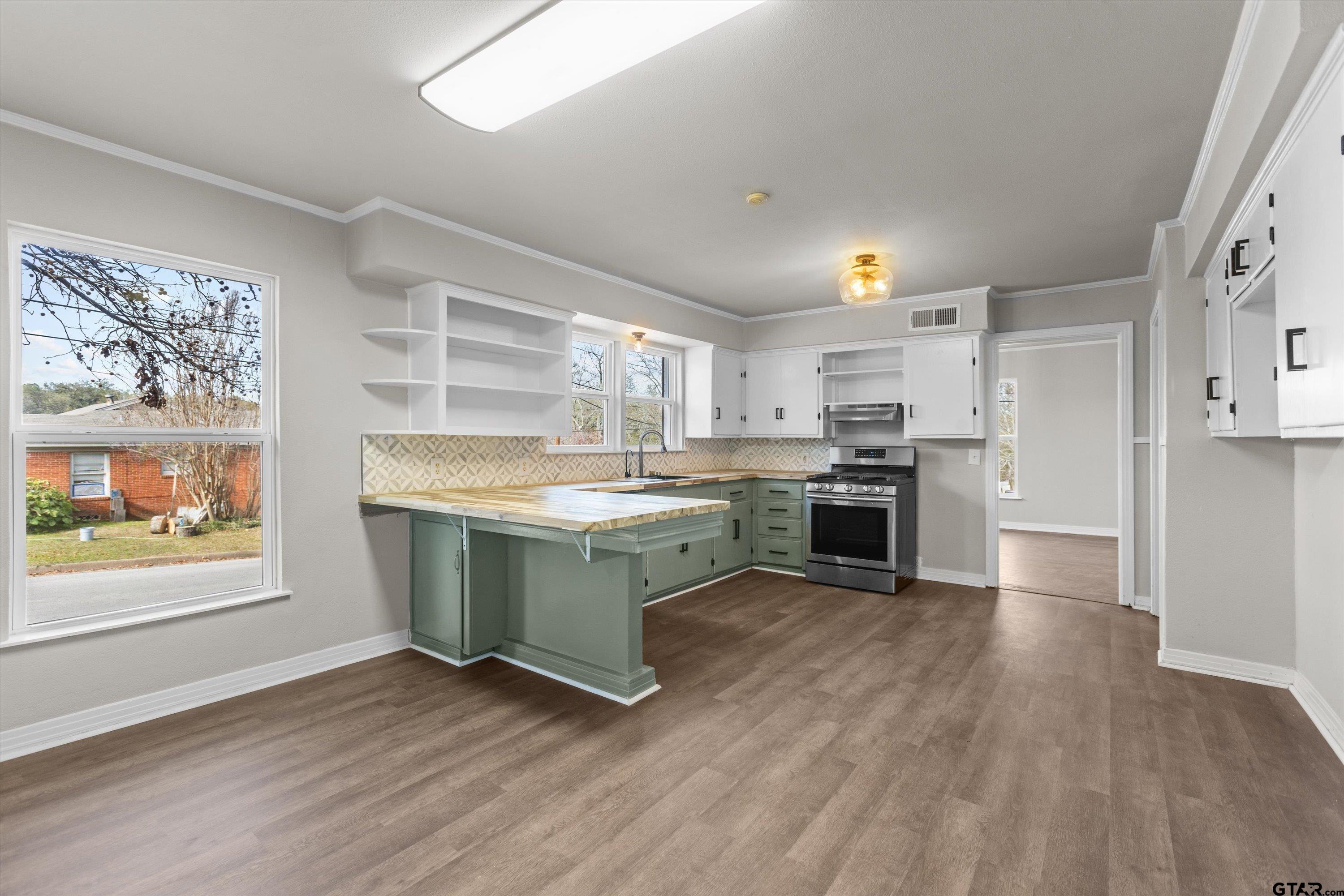 1330 Graham Drive Tyler, TX 75701 - Photo 9 of 22 a kitchen with stainless steel appliances granite countertop a stove top oven a sink dishwasher and a refrigerator with wooden floor