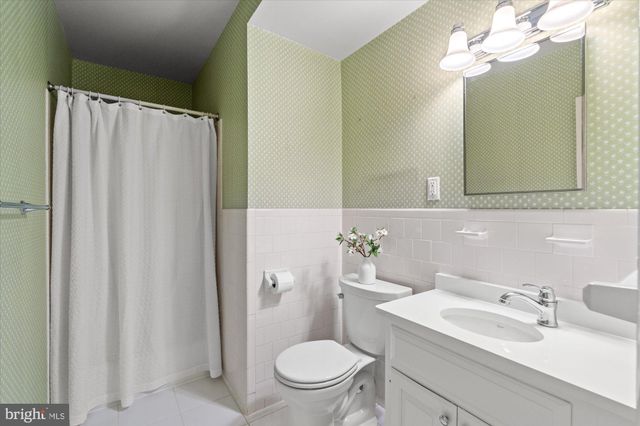 a bathroom with a sink vanity mirror and toilet