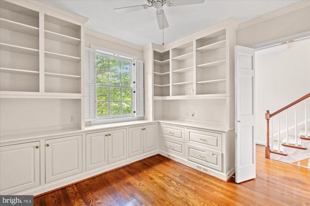 a view of a kitchen with white cabinets and a window