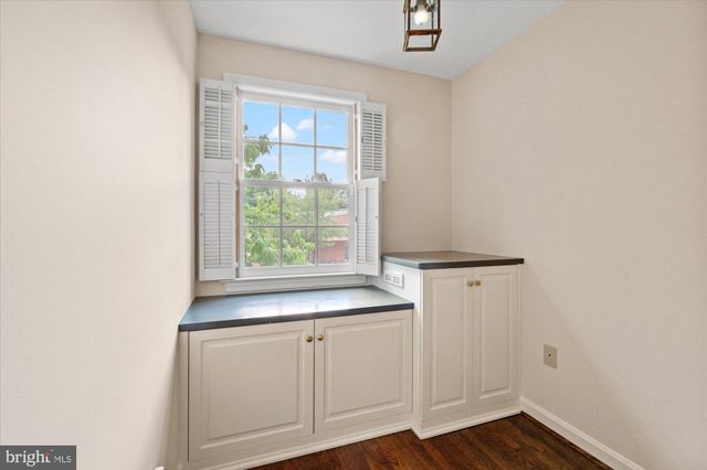 a view of kitchen with granite countertop cabinets and window