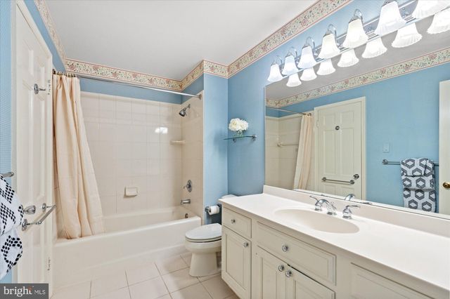 a bathroom with a sink a toilet a mirror a vanity and bathtub