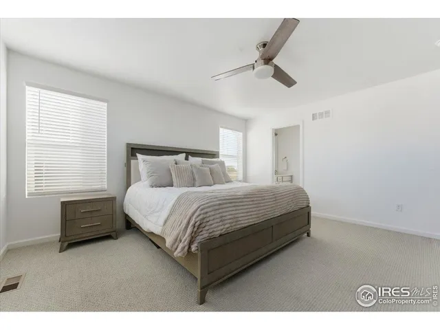 a spacious bedroom with a bed and a ceiling fan