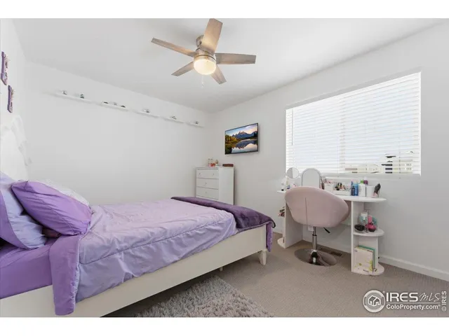 a bedroom with a bed a chandelier and a window