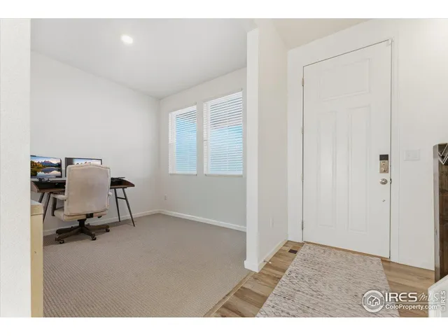 a view of a workspace with furniture and a window
