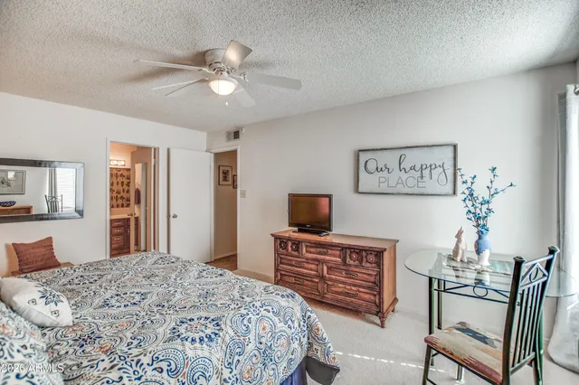 a bedroom with a bed dresser and a flat screen tv