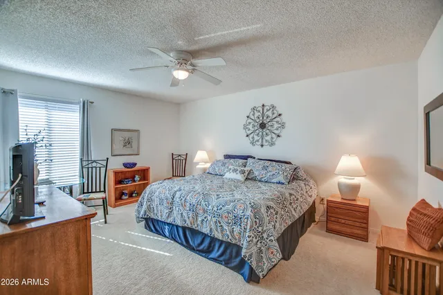 a bedroom with a bed and dresser with mirror