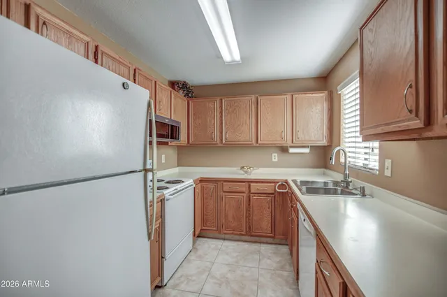 a kitchen with a sink a refrigerator and cabinets