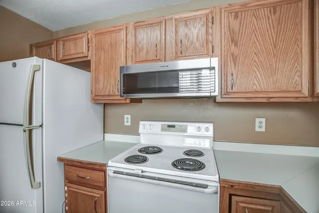 a kitchen with stainless steel appliances granite countertop white cabinets and refrigerator