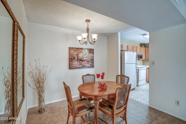 a dining room with furniture a chandelier and wooden floor