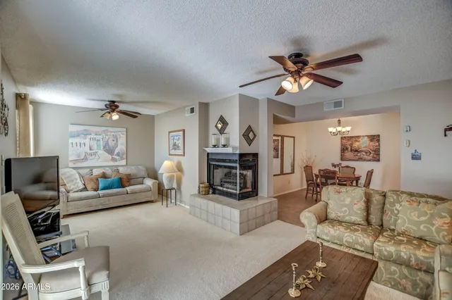 a living room with furniture a fireplace and a flat screen tv