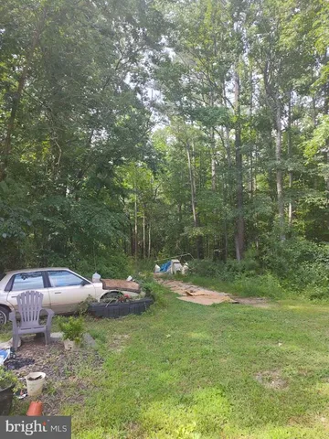 a backyard of a house with lots of green space and outdoor seating