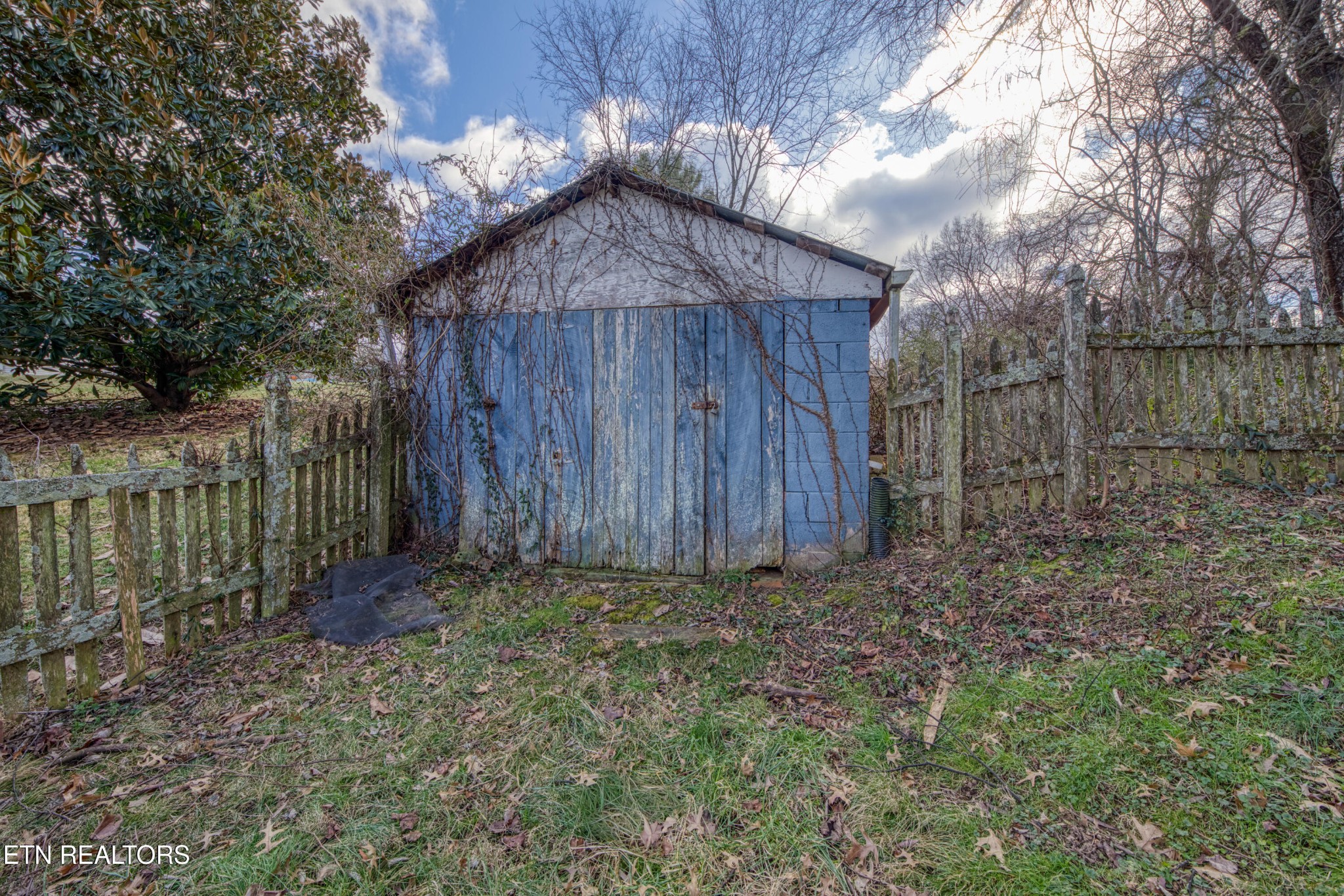 7700 McDaniel Road Knoxville, TN 37924 - Photo 5 of 18 a view of a backyard with large trees and wooden fence