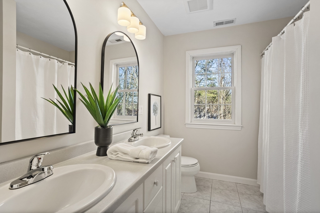 7 Eagles Nest Road Westford, MA 01886 - Photo 31 of 42 a bathroom with a granite countertop sink a large mirror and a shower