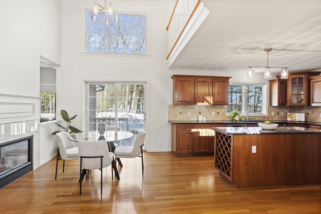 7 Eagles Nest Road Westford, MA 01886 - Photo 6 of 42 a dining hall with stainless steel appliances granite countertop a stove top oven a sink dishwasher a dining table and chairs with wooden floor