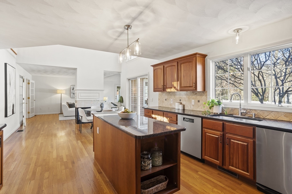 7 Eagles Nest Road Westford, MA 01886 - Photo 8 of 42 a kitchen with stainless steel appliances granite countertop a sink dishwasher stove and wooden cabinets with wooden floor
