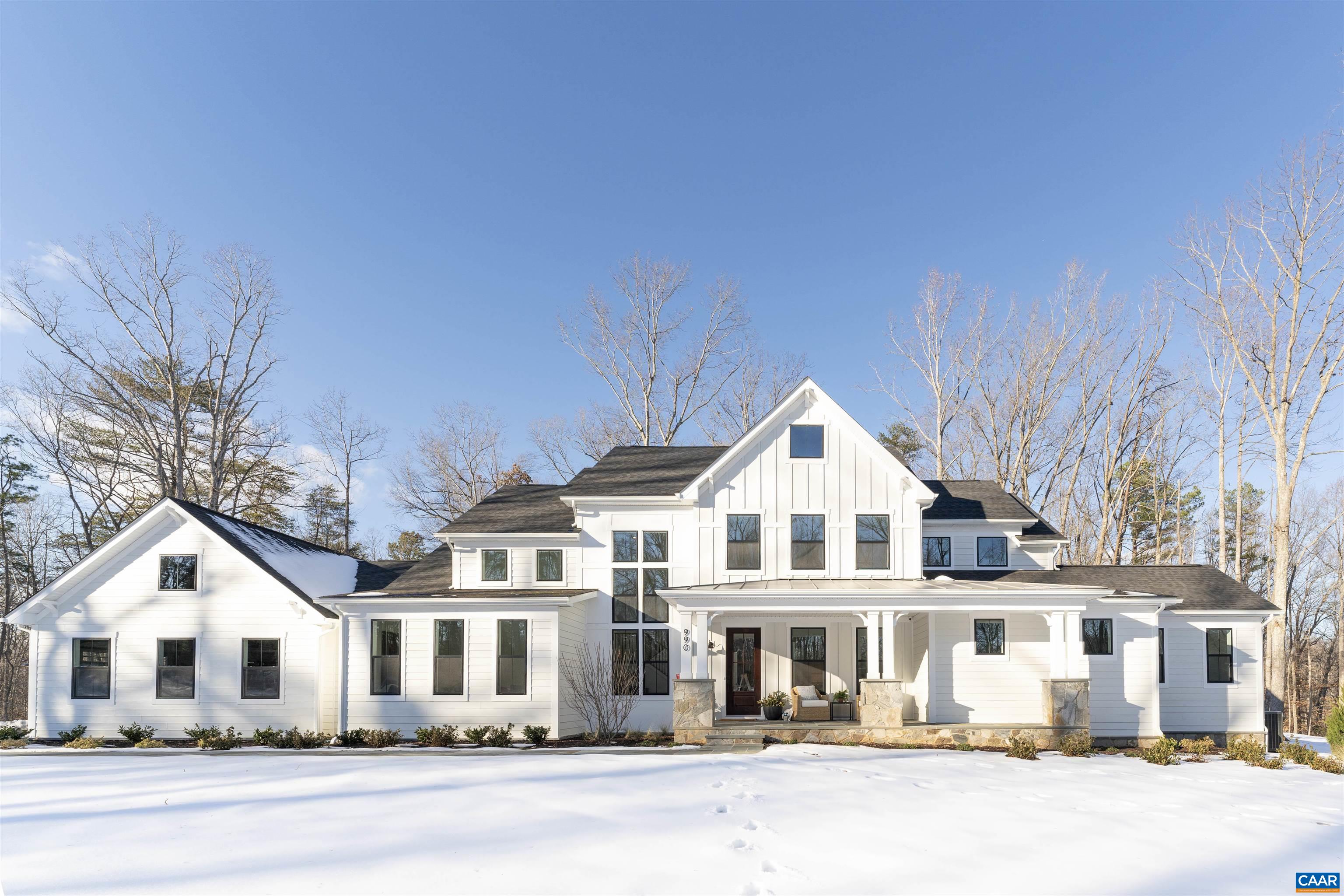 a view of a white house with a big yard and large trees