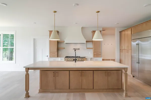 a kitchen with kitchen island granite countertop a sink stainless steel appliances and a window