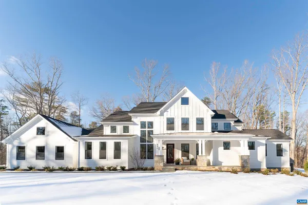 a view of a white house with a big yard and large trees