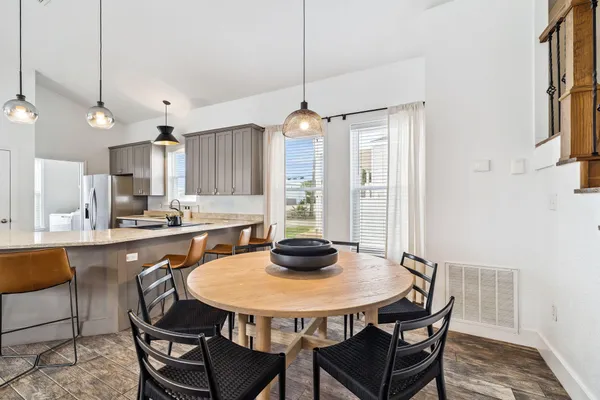 a kitchen with a dining table chairs and white cabinets