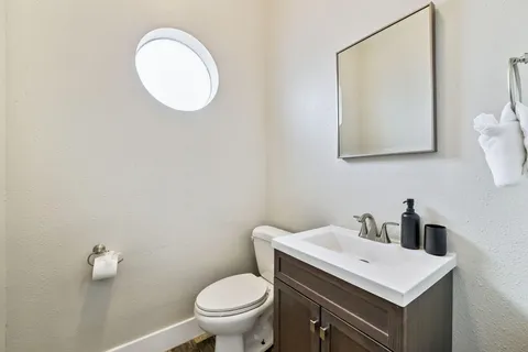 a bathroom with a toilet a sink and mirror