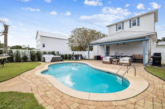 a swimming pool with outdoor seating and yard