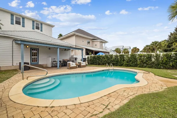 a view of a house with swimming pool and sitting area