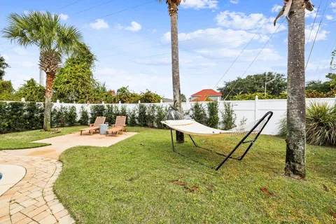 a view of a swimming pool with lawn chairs and a fire pit