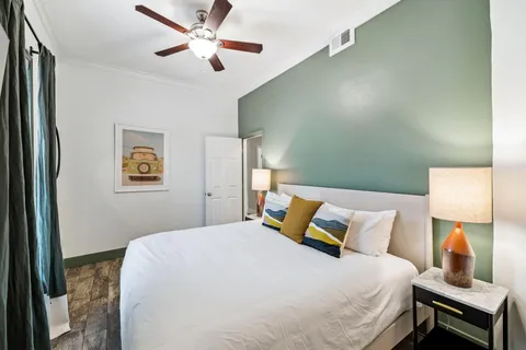 a bedroom with a bed and a lamp on the dresser