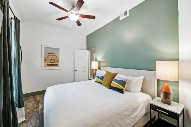 a bedroom with a bed and a lamp on the dresser