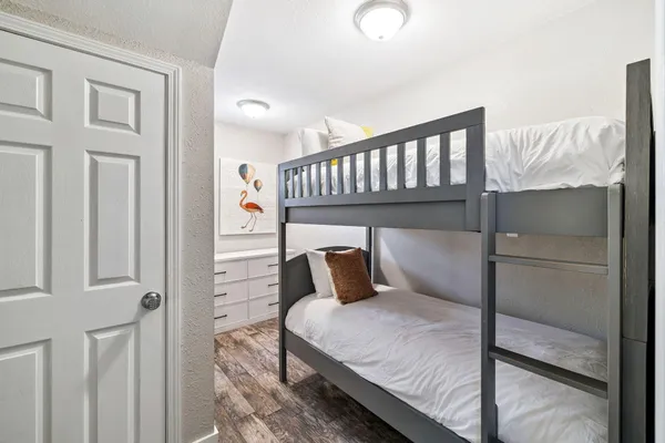 a bedroom with a bed and wooden floor